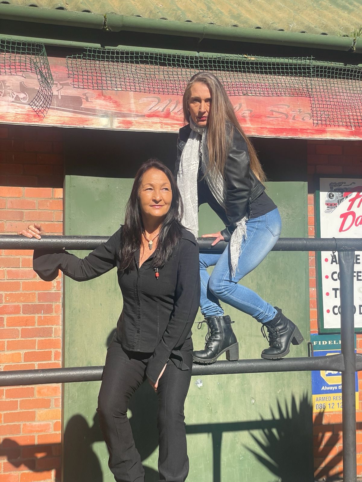 Tracey and Lindie posing together at a heritage railway station